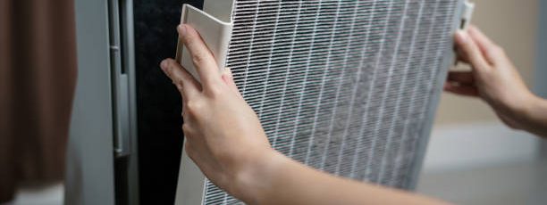 Woman hand open air purifier for clean dirty air purifier HEPA filter.